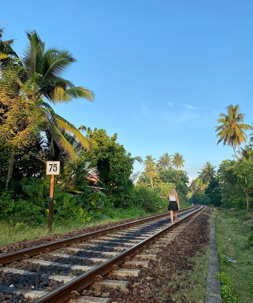 femme marchant sur les rails de chemin de fer au sri lanka